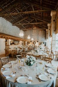 a long table with white plates and glasses in a room at Mas des Comtes de Provence in Tarascon