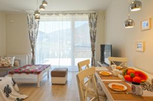 een eetkamer en een woonkamer met een tafel en stoelen bij Sun&Sport Apartament PARZENICA w super lokalizacji niedaleko wyciagu in Szczyrk