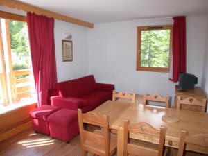 ヴァールにあるL'Ecrin des Neigesのリビングルーム(赤いソファ、テーブル付)