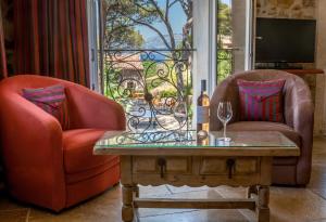 a living room with two chairs and a table and a window at L' Escapade Hôtel & Restaurant in Le Pradet