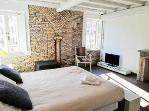- une chambre avec un grand lit et un mur en briques dans l'établissement Incredible Views in Campo de Fiori, à Rome