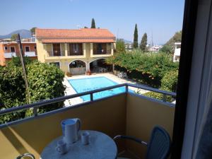 een balkon met uitzicht op een zwembad bij Kalypso Gouvia in Gouvia