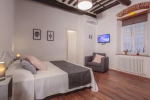 a bedroom with a bed and a chair in it at San Pierino Charming Rooms in Lucca