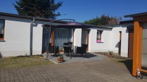 a patio with a table and an umbrella at Zimmervermietung Kolkwitz - Pension Geisler in Kolkwitz