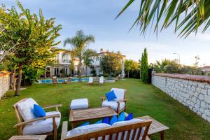 a backyard with two chairs and a wooden table at Alaçatı Casa Bella +12 in Alacati