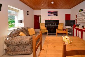 een woonkamer met een bank en een tafel bij Cottage 194 - Leenane in Leenaun