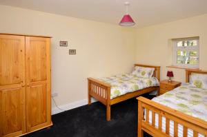 a bedroom with two beds and a dresser at Cottage 194 - Leenane in Leenaun