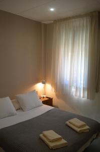Un dormitorio con una cama con dos toallas encima. en Fonda Ca La Paula, en Castellfollit de la Roca