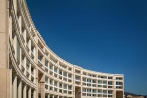 a large white building with a blue sky in the background at Crescent Moon in Salerno