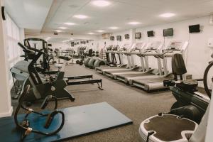 un gimnasio con cintas de correr y máquinas en una habitación en Nant Ddu Lodge Hotel & Spa en Merthyr Tydfil