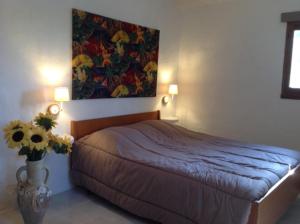 - une chambre avec un lit et une peinture murale dans l'établissement Le bastidon du Luberon, à Caseneuve