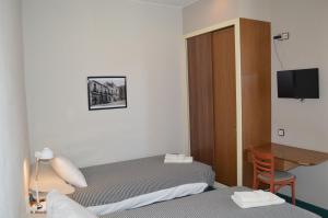 a hotel room with two beds and a desk at Fonda Ca La Paula in Castellfollit de la Roca