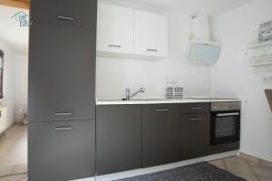 a kitchen with black and white cabinets and a sink at Bungalow near by Playmobil and fair Nuremberg in Zirndorf