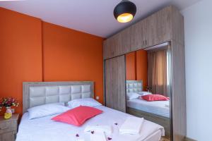 2 camas en un dormitorio con paredes de color naranja en Stay Inn Apartments on 33 Sayat-Nova avenue, en Ereván