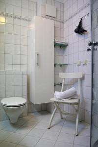 a bathroom with a toilet and a chair in it at K & R Appartements Binz in Binz +32 photos