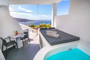 a hotel room with a balcony overlooking the ocean at Theodora Suites in Oia