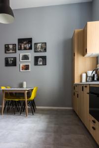 a kitchen with a table and yellow chairs at Apartament Jana Matejki in Poznań