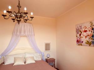 a bedroom with a bed with a chandelier at Lago Trasimeno - Venere in Borghetto