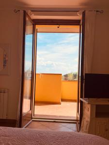 a bedroom with a door open to a balcony at Lago Trasimeno - Venere in Borghetto