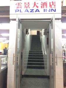 eine Treppe, die zu einem Gebäude mit einem Schild führt in der Unterkunft Plaza Inn in Sibu