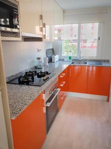 cocina con armarios de color naranja y horno con fogones en PALOMA DREAM, en Benidorm