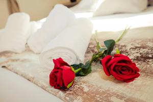 two red roses and towels on a bed at Soleil B&B Gozo in Għarb