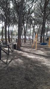 un parco con panchine, altalene e alberi di Un mare di relax a Follonica