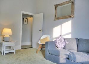 a living room with a blue couch and a mirror at Donnybrook Townhouse in Dublin +28 photos