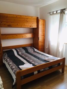 een slaapkamer met een groot bed met een houten hoofdeinde bij Apartments Fuchs in Umag
