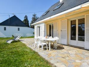 a patio with a table and chairs next to a house at Peaceful holiday home near the beach in Pénestin