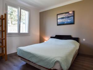 a bedroom with a bed and two windows at Peaceful holiday home near the beach in Pénestin