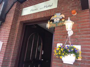 a door to a brick building with a lamp and flowers at Hana Aparthotel in Hamburg