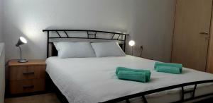 a bedroom with a bed with two green pillows on it at Apartmani Bilić in Korenica