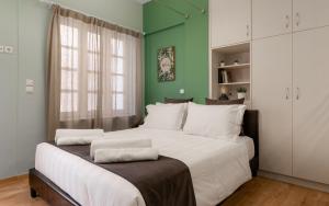 een slaapkamer met een groot wit bed en een groene muur bij Monastiraki Urban Apartments in Athene
