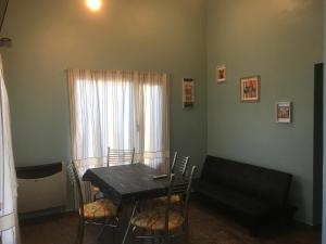 a dining room with a table and chairs and a couch at Altos de Ayelen in Esquel