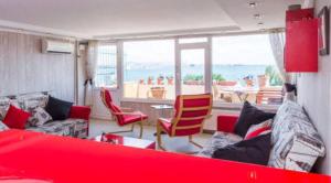 伊斯坦堡的住宿－Front of Sea View Apartments Sultanahmet SEA VIEW，客厅配有红色的沙发和椅子
