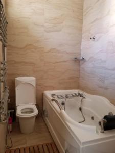 een badkamer met een bad, een toilet en een wastafel bij NIZAMI Street 1 Bedroom in Baku