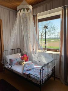 a bedroom with a canopy bed with a window at 29 Haster Straße in Bad Nenndorf