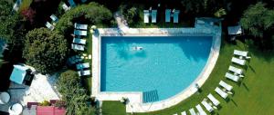an overhead view of a large swimming pool with lawn chairs at Hotel Saltauserhof in Saltusio
