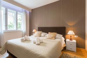 1 dormitorio con 1 cama grande y 2 toallas. en Golden Split Rooms en Split