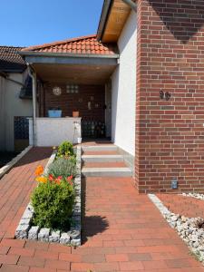 a house with a brick walkway with flowers in front at 29 Haster Straße in Bad Nenndorf