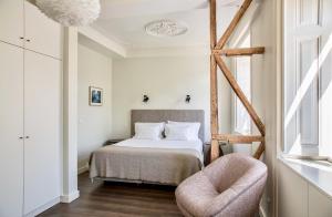 ein Schlafzimmer mit einem Bett, einem Stuhl und einem Fenster in der Unterkunft Hermitage Castelo - Casa Chafariz in Lissabon