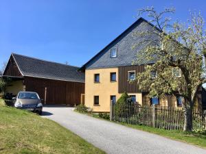 ein Haus mit einem davor geparkt in der Unterkunft Ferienwohnung Hänel in Hinterhermsdorf