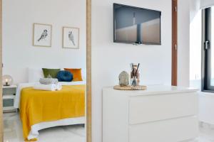 - une chambre avec un lit et une télévision murale dans l'établissement Phaedrus Living Seaview Luxury Flat Marina Court 213, à Paphos