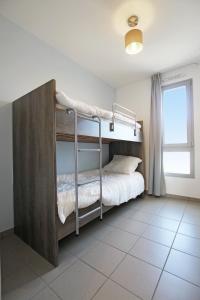 een slaapkamer met een stapelbed in een kamer met een raam bij Evancy Villa les Margats in Bray-Dunes
