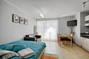 sypialnia z łóżkiem i stołem oraz kuchnia w obiekcie Apartament Magnolia Centrum Taras w Zakopanem