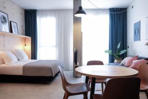圣塞瓦斯蒂安Talo Urban Rooms的一间带床和桌子的酒店房间