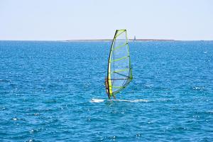 a person is windsurfing in the middle of the ocean at Arena Medulin Mobile Homes in Medulin