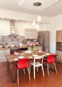 a kitchen with a wooden table and red chairs at Residenza Giulietta in Rimini