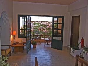 a living room with a door open to a patio with flowers at Rea Hotel in Palaiochora